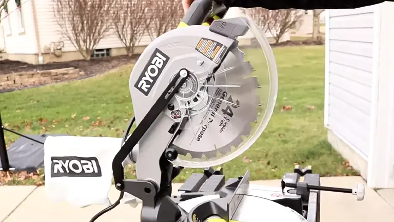 Ryobi 10-inch sliding compound miter saw with LED on stand in a suburban backyard