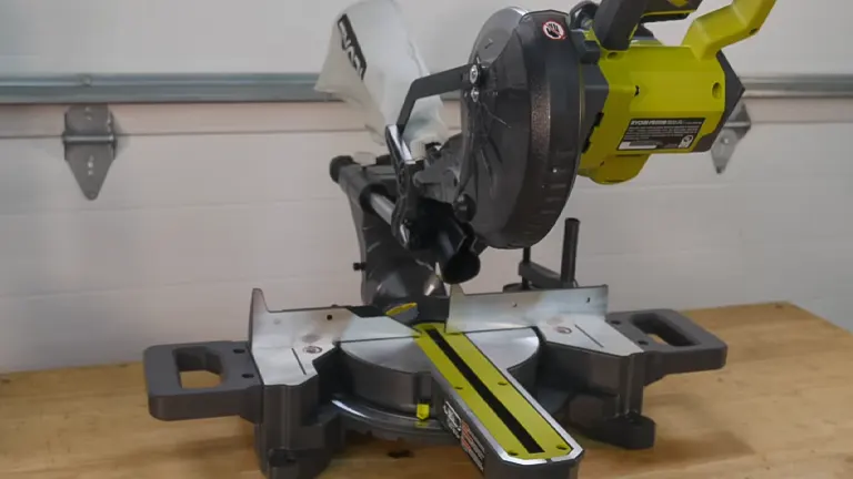 “Ryobi PBT01B ONE+ 18V 7-1/4” Sliding Compound Miter Saw on a gray workbench with a white wall in the background
