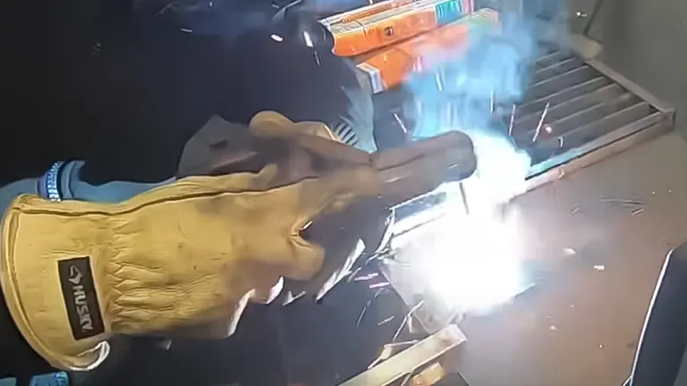 Person welding with bright sparks and blue smoke using an AMICO MIG-160 Flux Stick TIG Arc 3-in-1 Welder