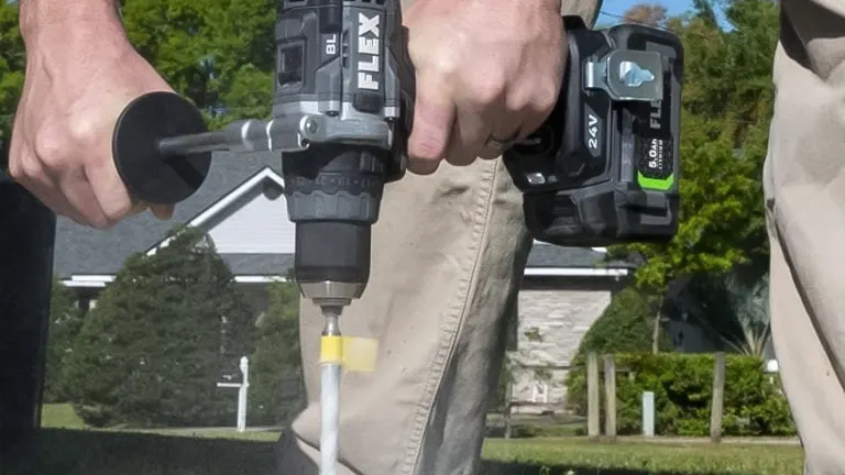 A person using a Flex 24V Max Hammer Drill with Turbo feature on a concrete surface