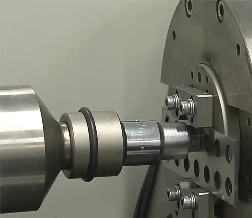 Close-up of a metal chuck and bolts on a wood lathe machine in a workshop