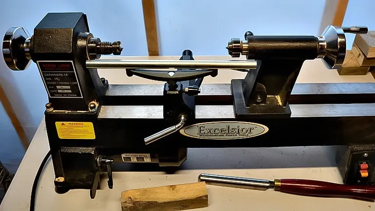Wood lathe labeled ‘Excelsior’ with tools on a workbench