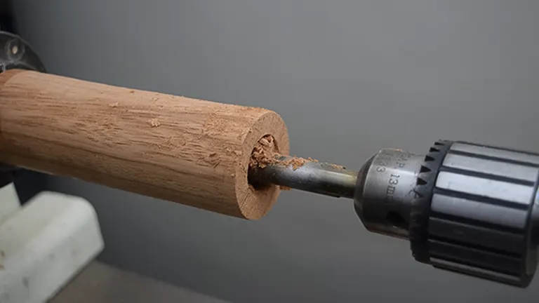 Close-up of wood lathe with drill bit and wood shavings