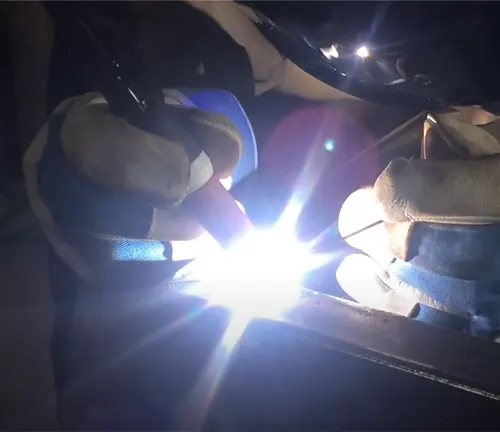 A person welding metal, with bright light illuminating the work area, using an Everlast Power 185DV AC/DC TIG Stick Welder