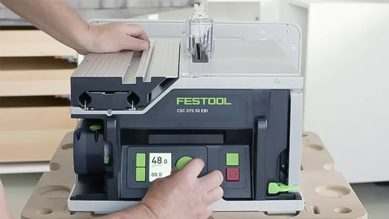 Person using a Festool Table Saw CSC SYS 50 to cut wood in a well-lit workshop