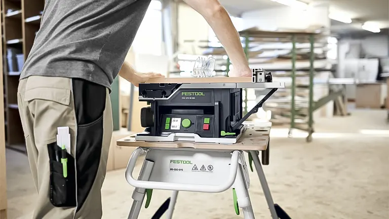 Person operating a compact Festool Table Saw CSC SYS 50 in an organized workshop