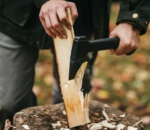 Person splitting wood with Fiskars X7 Hatchet outdoors