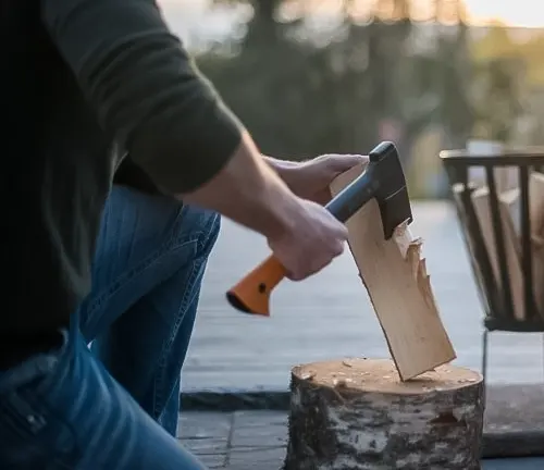 Person using a Fiskars X7 hatchet to split wood