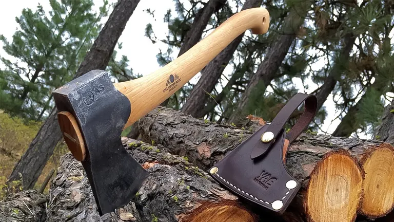 Gransfors Bruk Small Forest Axe with a leather sheath embedded in a log in a forest setting