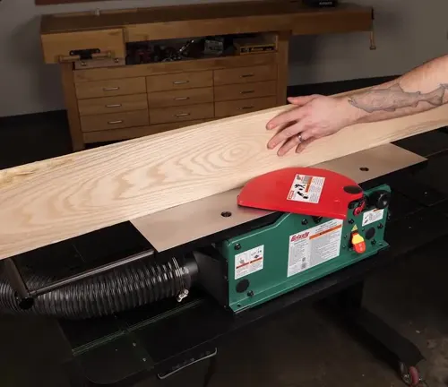 Green Grizzly Industrial G0945 6-inch Benchtop Jointer in use on a wooden board