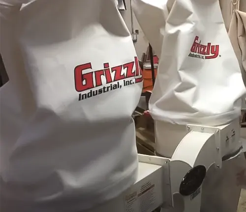 “Two Grizzly Industrial dust collectors with white collection bags in a workshop setting