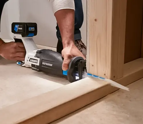 Person using a HART 20-Volt Reciprocating Saw to cut wood in an ongoing construction project