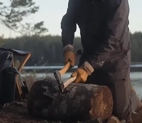 Person using a Hultafors ABY Small Forest Axe to chop wood in an outdoor setting