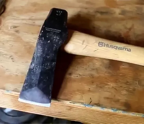 Husqvarna S21 splitting maul with a wooden handle, placed on a wooden surface