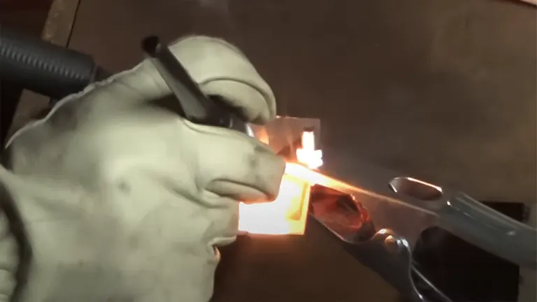 Person using a PRIMEWELD TIG225X 225 Amp Tig/Stick Welder Machine with bright sparks visible from the welding process