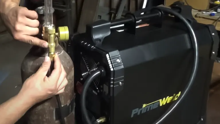 a person’s hands adjusting the settings on a PRIMEWELD TIG225X 225 Amp Tig/Stick Welder Machine