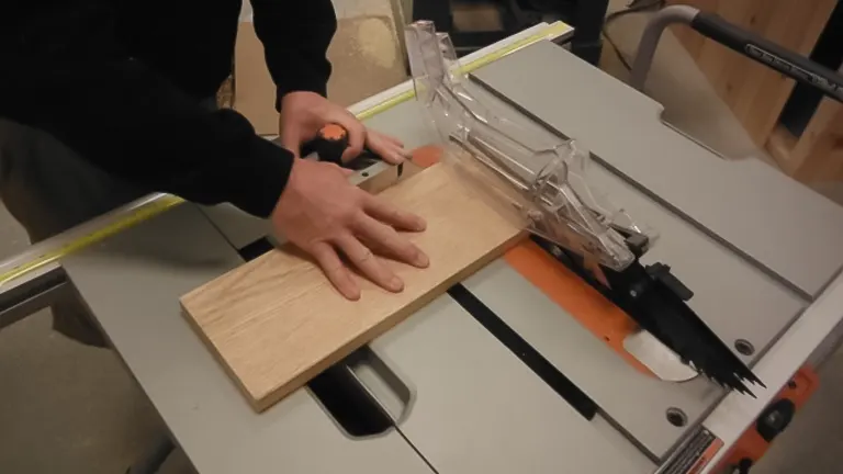 Person using a RIDGID 10 Inch Table Saw R4510 to cut a piece of wood in a workshop