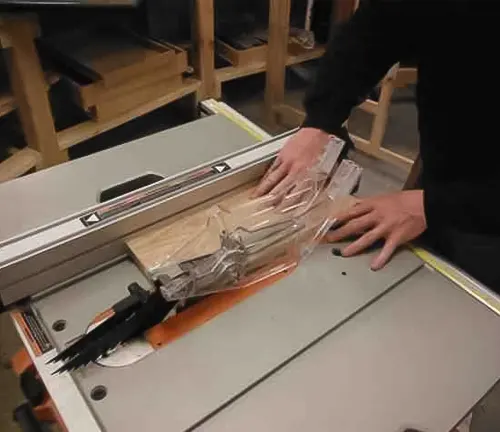 Person using a RIDGID 10 Inch Table Saw R4510 to cut wood in a workshop