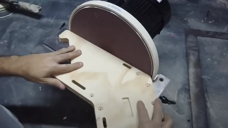 Person using Shop Fox W1828 12-Inch Disc Sander on a wooden piece in a workshop