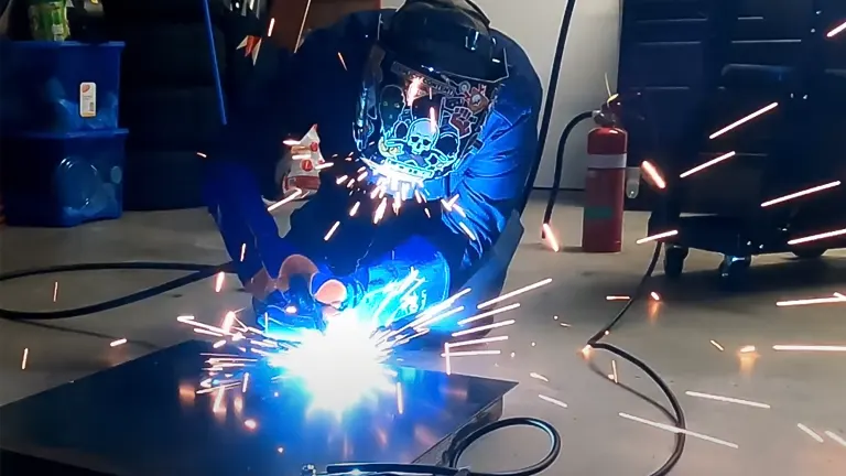A person using a UNIMIG Viper 185 3-in-1 Mig/Tig/Stick Welder, creating bright sparks