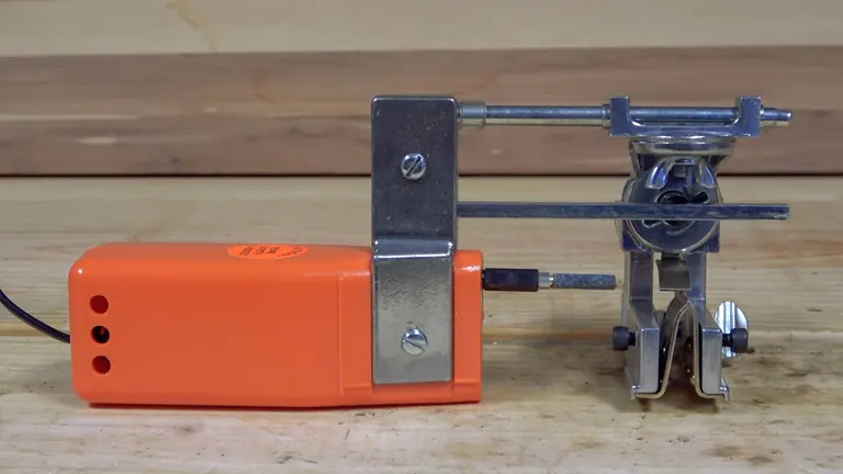 Granberg Chainsaw Sharpener with an orange body and metallic component, placed on a wooden surface