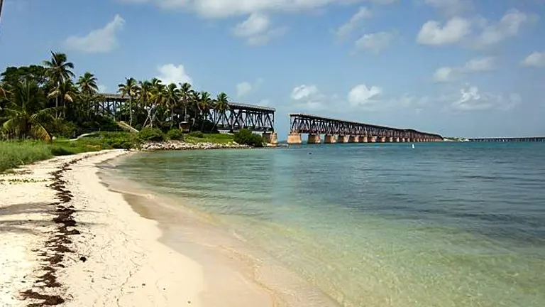 Scenic view of Bahia Honda State Park with a sandy beach, clear waters, and an old railway bridge
