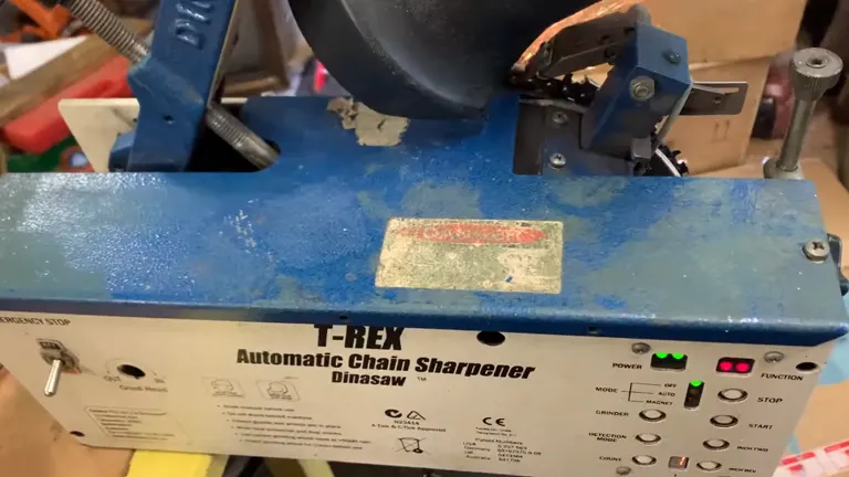 Used T-Rex automatic chainsaw sharpener with control buttons and labels in a workshop setting