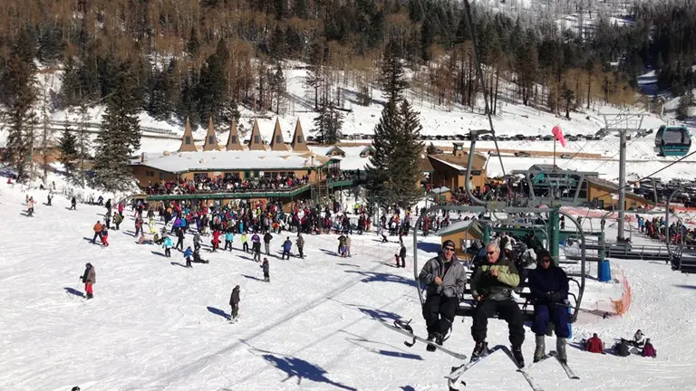 bustling scene at the Ski Apache resort, filled with skiers and snowboarders