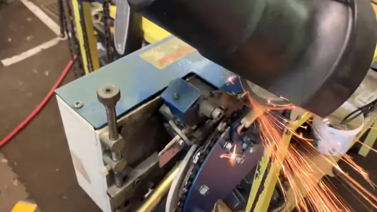 T-Rex Chainsaw Sharpener actively sharpening a chainsaw, emitting sparks in a workshop setting