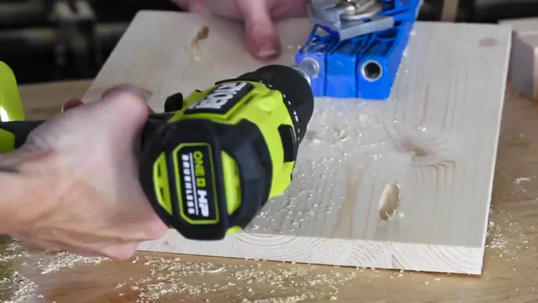 A close-up of a green and black cordless drill making a hole in a wooden board.