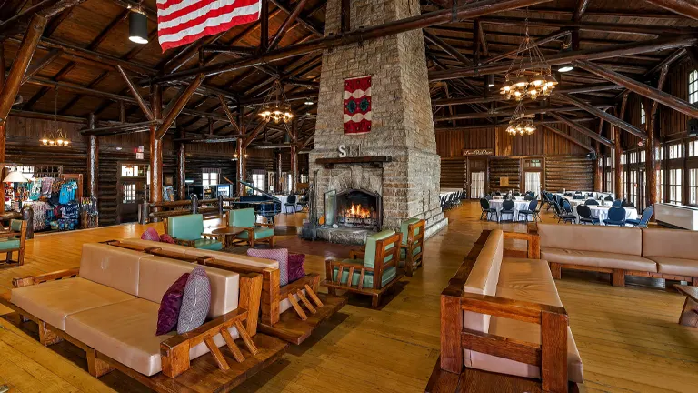 historic lodge with a stone fireplace, rustic wooden furniture, and a dining area