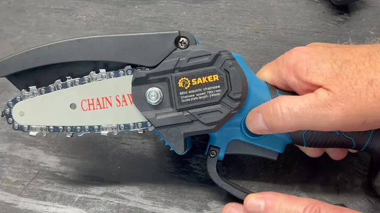 a close-up of a person’s hand holding a Saker mini electric chainsaw