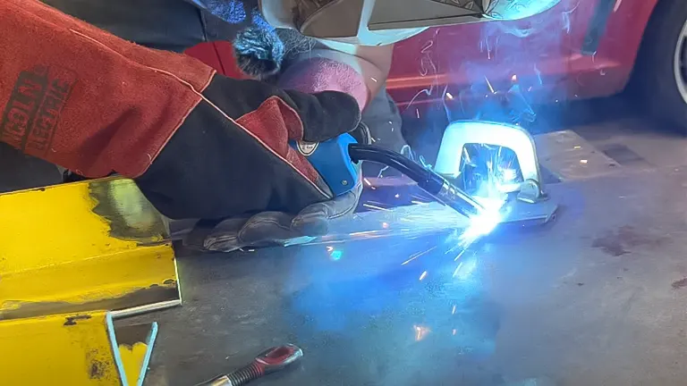 Person adjusting an AZZUNO 135 Amp MIG 3 in 1 MP Welder in a workshop