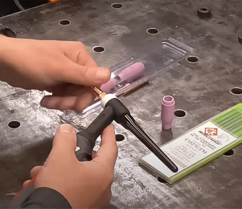 Person assembling the YesWelder Firstess CT2050 TIG torch with accessories on a workbench