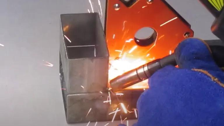 Person welding metal with a Bossweld MST-185 Plus 3-In-1 Inverter Welder, emitting bright sparks