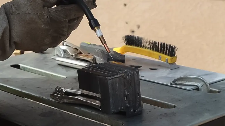 process of welding a metal object on a table with various tools around