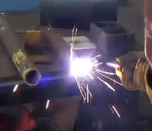Welder working on metal, creating bright sparks