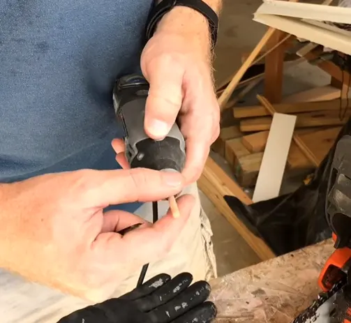 Person securely fitting a grinding wheel into a Dremel tool for safe operation