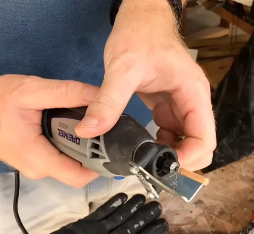 Person attaching a sharpening guide to a Dremel tool for chains