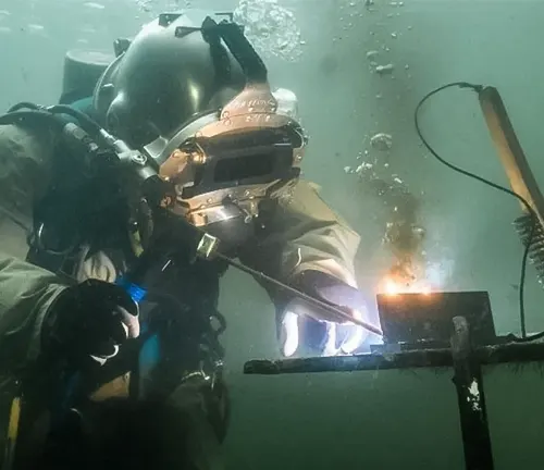 An underwater welder in action, surrounded by bubbles and murky water