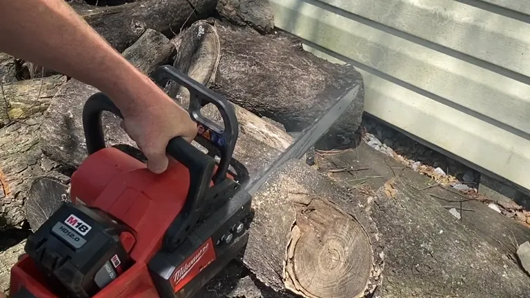Person cutting log using chainsaw