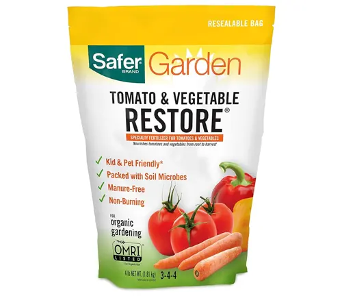 A package of Safer Brand Garden Tomato & Vegetable Restore fertilizer, labeled as kid and pet friendly, and packed with soil microbes for organic gardening.

