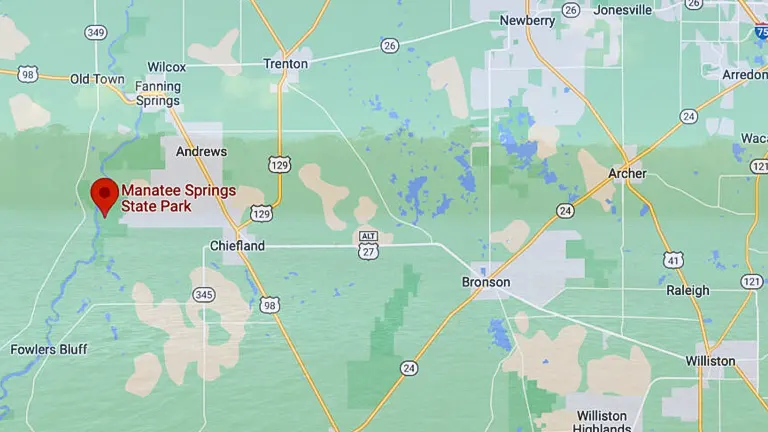 Map screenshot showing the location of Manatee Springs State Park marked with a red pin, west of Gainesville, Florida, with surrounding towns and roadways.