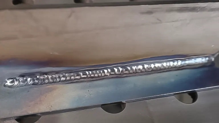 Smooth weld bead on a steel plate over a perforated table