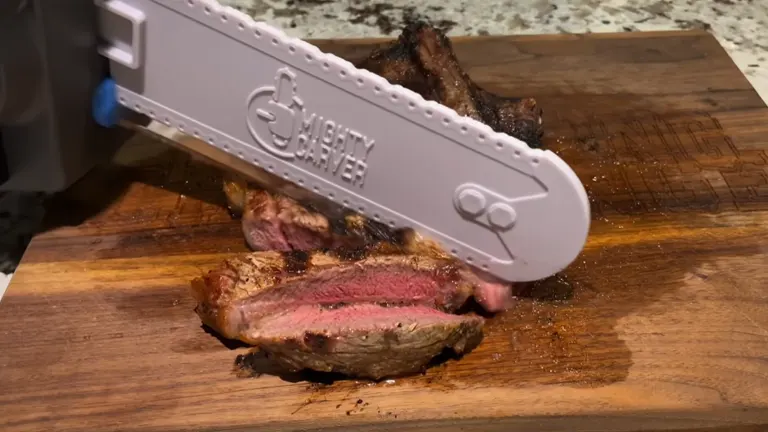 Mighty Carver Electric Carving Knife used in cutting steak on top top of cutting board