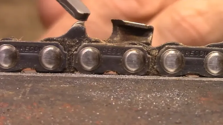 Close-up of a chainsaw chain being inspected for teeth and depth gauge condition