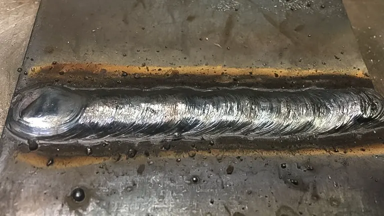 Close-up view of a clean, deep penetrating stick welding seam on a metal surface, showcasing Method 1 (DCEP) welding technique