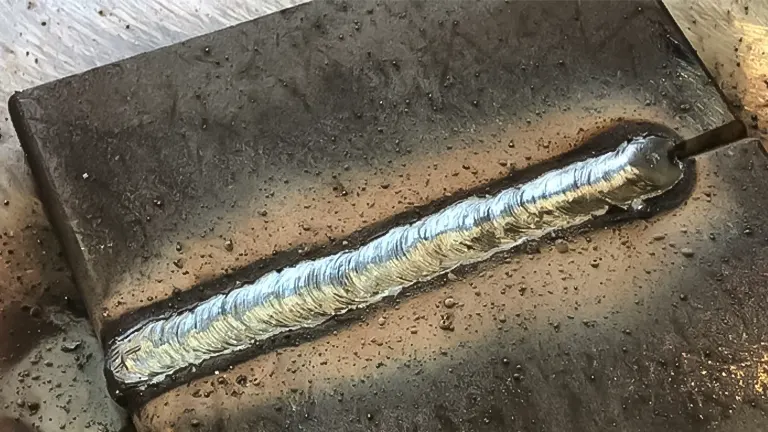 Freshly welded seam on a metal surface demonstrating DCEN stick welding method for reduced distortion and efficient electrode use