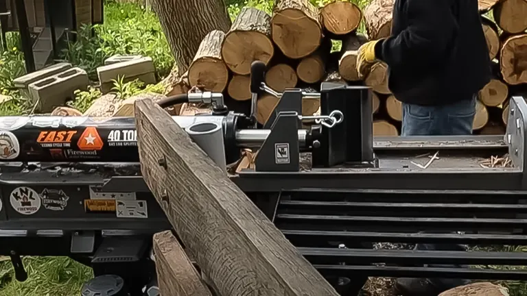 A Countyline 40-Ton Log Splitter in operation with a large log positioned for splitting