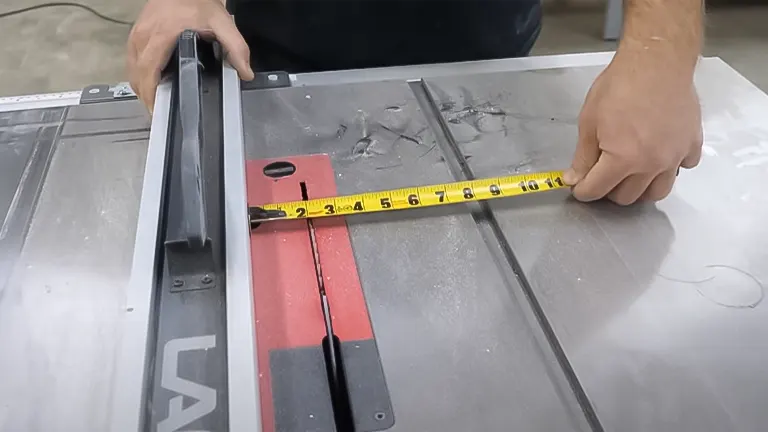 Hands measuring a saw guide on a table saw with a tape measure for precise cutting